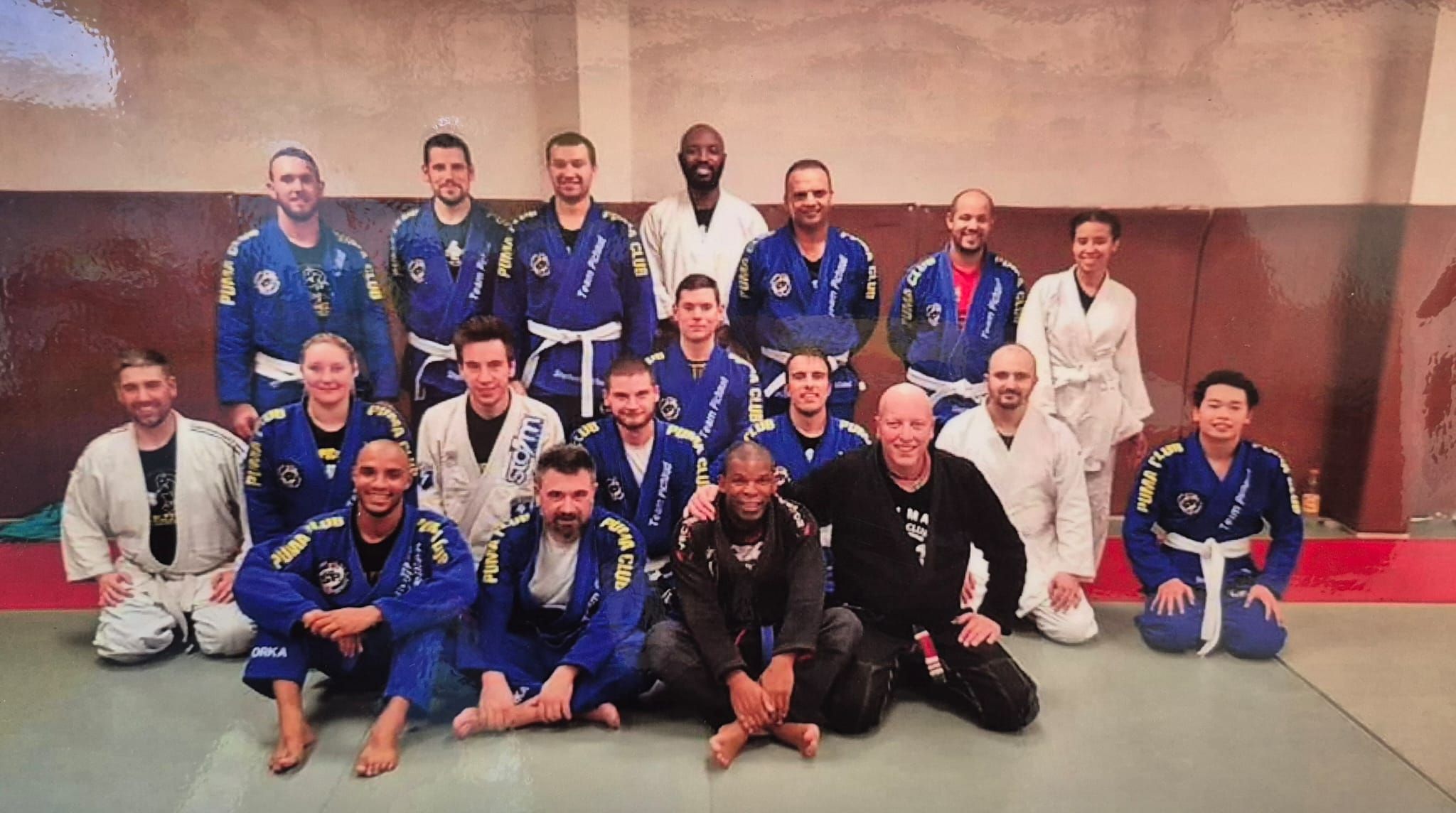 Pratiquants de jiu-jitsu brésilien en kimono bleu et blanc, réunis sur le tatami.